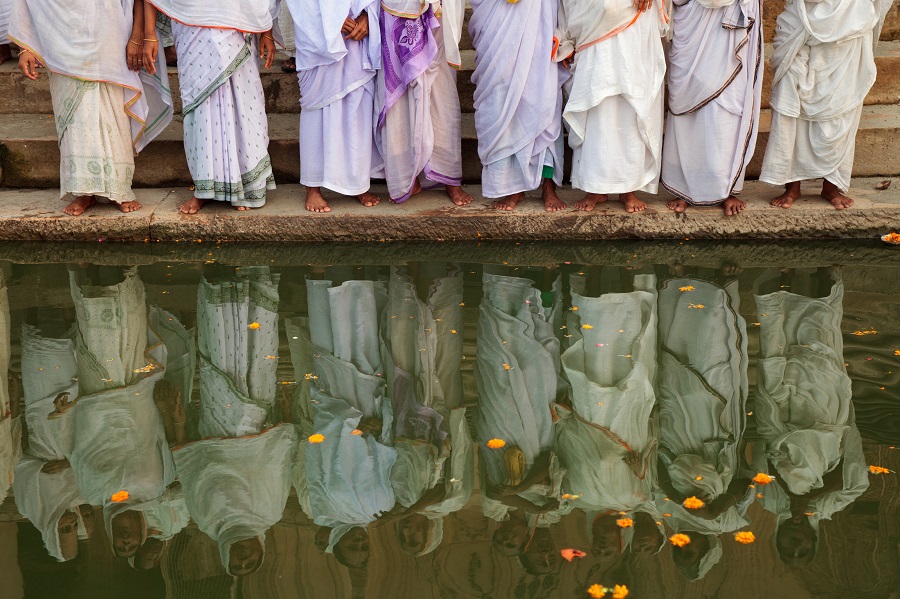 6 Sep 2014 - Vrindavan, India. A group of widows pray on the ghats of the Yamuna river in the holy town of Vrindavan, Uttar Pradesh. Also known as the City of Widows, some 20,000 women have made the journey to this city of 4,000 temples to escape abuse in their homes or are cast out by their husbands' families so they won't inherit property. Image credit: Sara Hylton